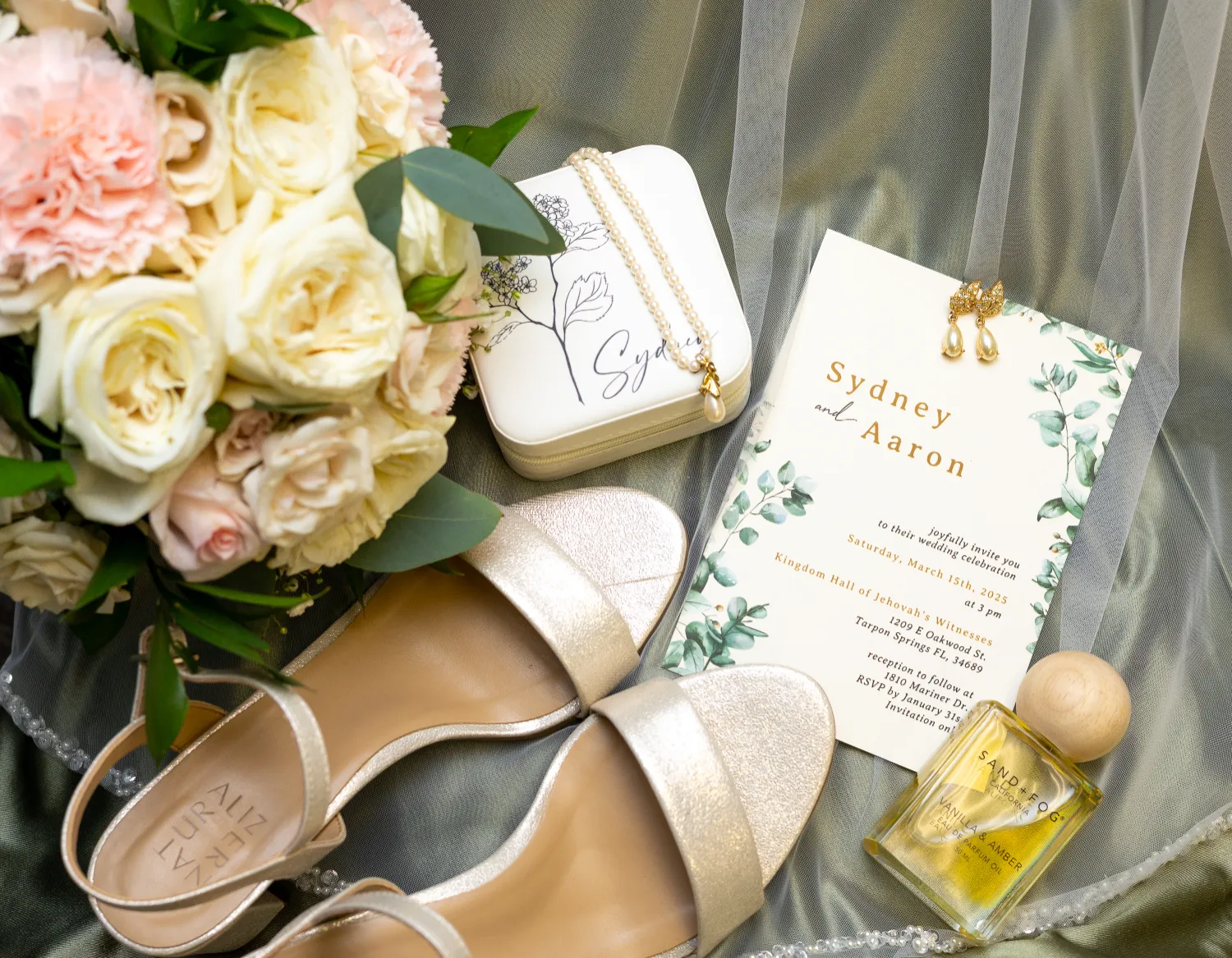 A pair of wedding shoes, a vibrant bouquet, and a beautifully designed wedding invitation displayed together